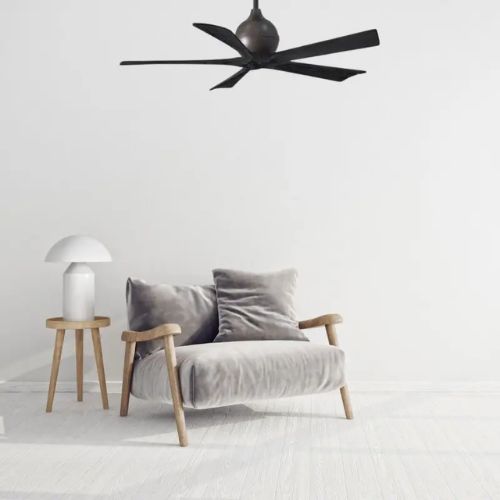 Ventilateur de plafond moderne au-dessus d’un salon minimaliste, siège confortable et lampe sur table, sens rotation ventilateur plafond hiver évoqué.