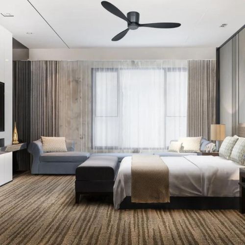 Ventilateur de plafond noir avec trois pales suspendu au-dessus d'une chambre moderne lumineuse.